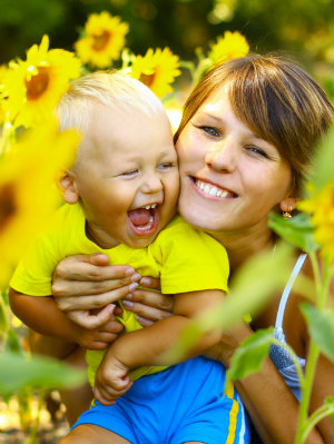 Mother and Son Laughing Outdoors Among Sunflowers
