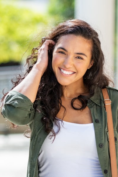smiling brunette student outdoors on a walk