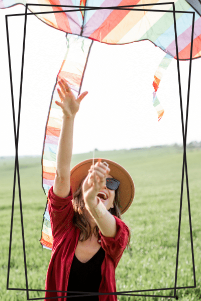 happy woman in hat flies colorful kite
