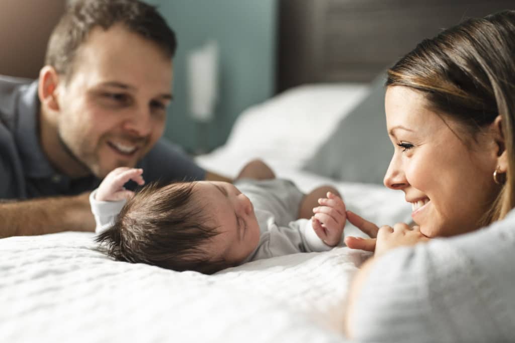 Couple With Newborn Baby on Bed