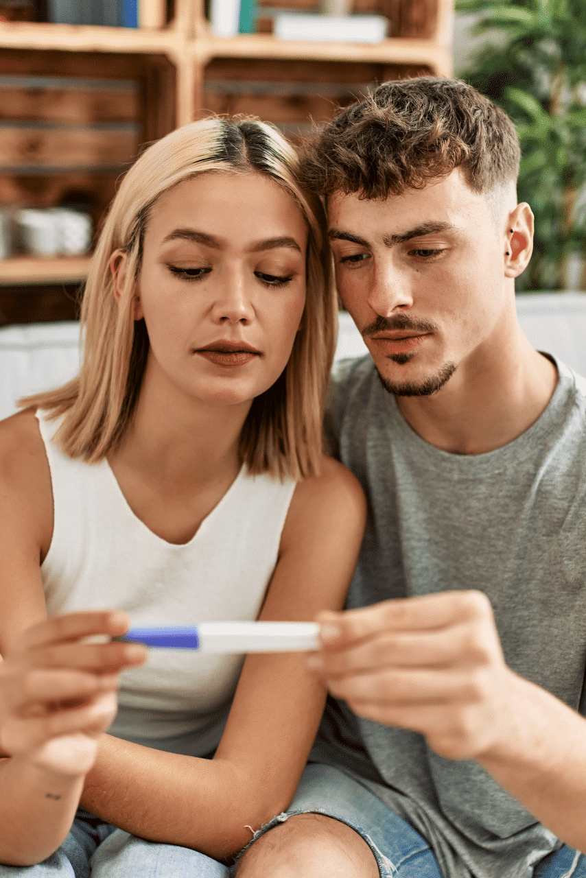 serious young couple looks at their pregnancy test