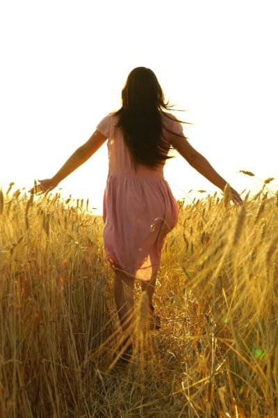 brunette walking through wheat field
