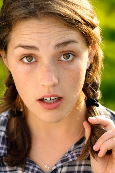 surprised brunette with braids outdoors