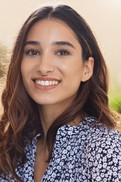 young brunette woman smiles outdoors