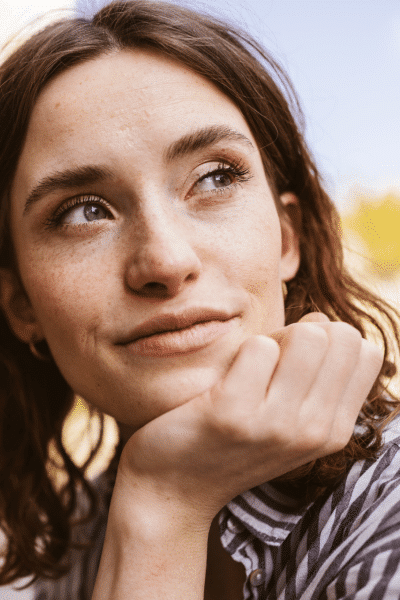 young woman thinking with chin resting on hand