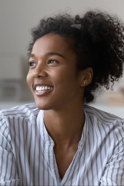 smiling young black woman in striped shirt young black woman smiles wearing striped shirt