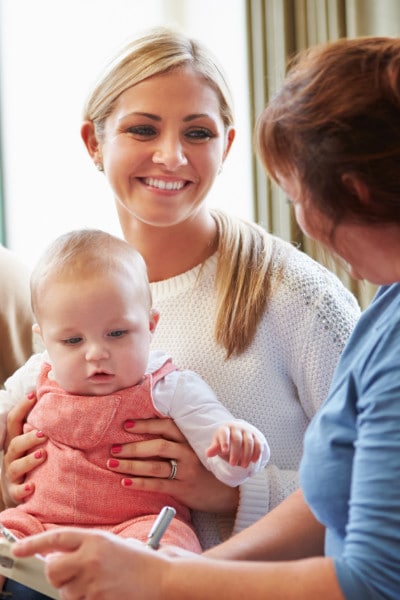 young mother and baby with supportive educator young mother and baby get supportive education from woman