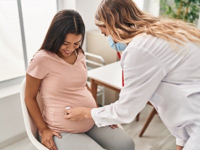 Health care provider checks pregnant woman for medical pregnancy support