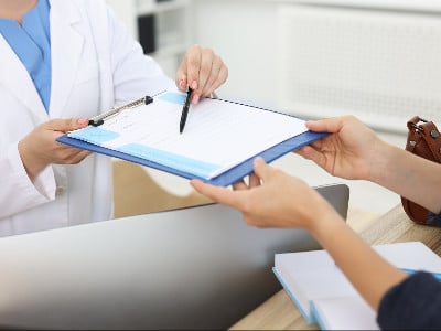 nurse explains form on clipboard to patient clipboard