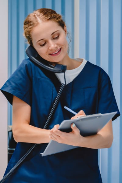 Nurse talks on phone to client about their confidential STI test results.