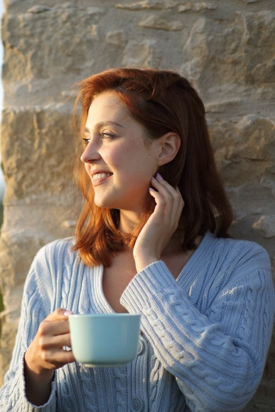 contented red haired woman looks toward light