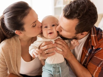 adoptive parents kissing baby