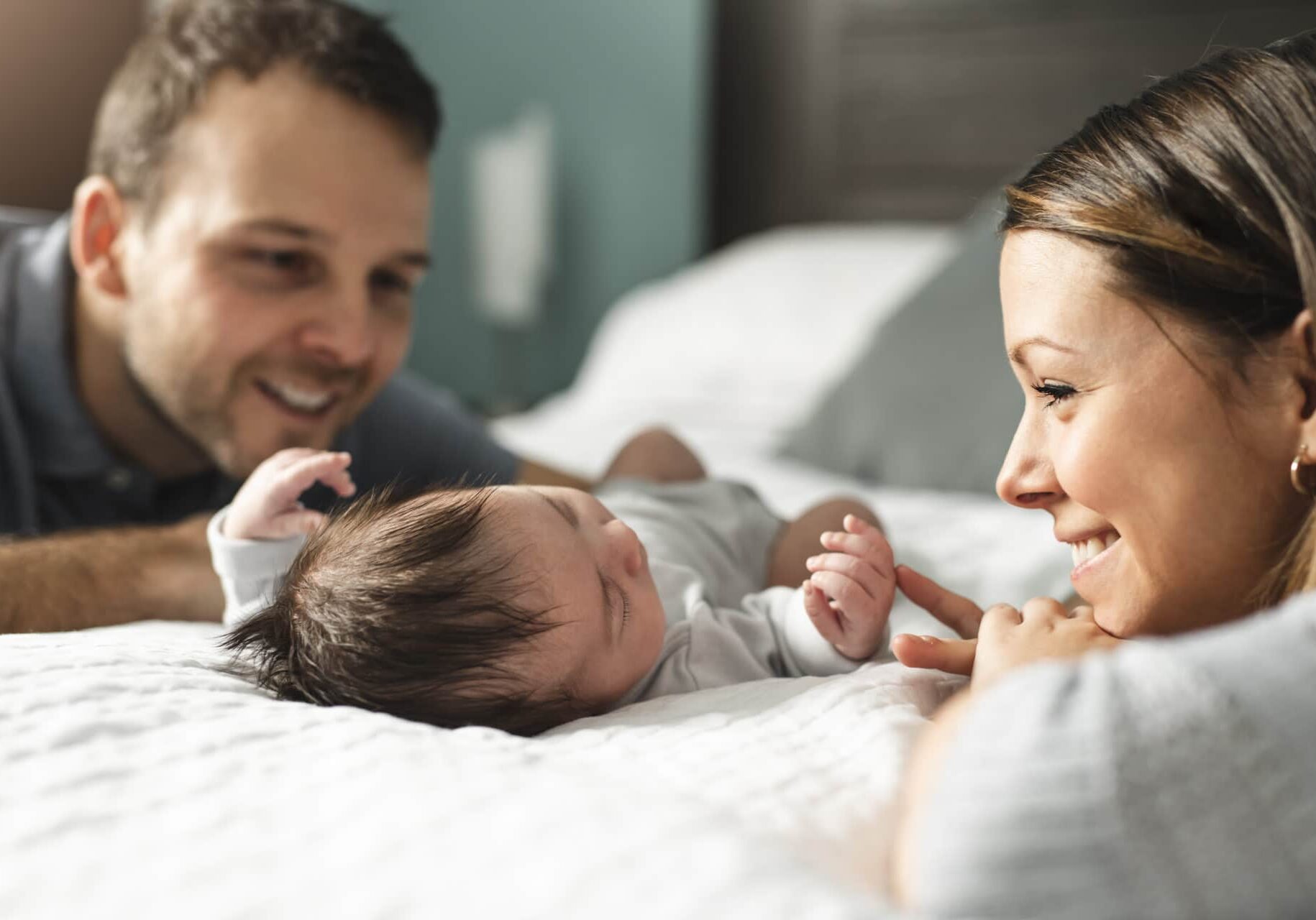 Couple With Newborn Baby on Bed