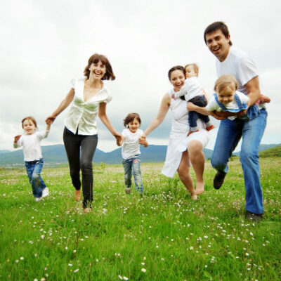 Family Running in Field Holding Hands