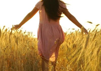 brunette walking through wheat field
