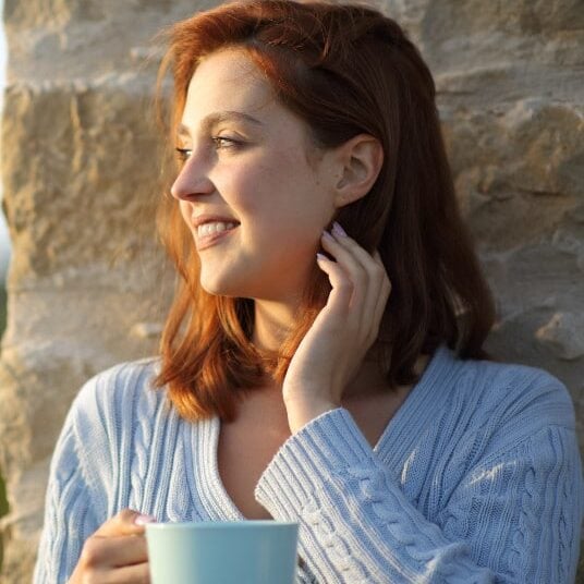 contented red haired woman looks toward light