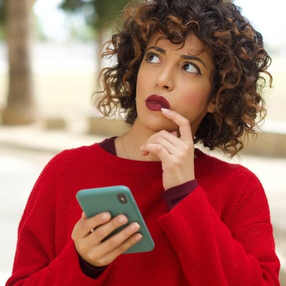 young woman with cell phone looks worried